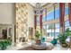 Bright living room with a stone fireplace, a chandelier, and large windows offering views of the lake at 11900 Lake Butler Blvd, Windermere, FL 34786