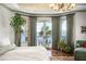 Bright bedroom featuring a balcony overlooking the water, hardwood floors, and stylish furnishings at 11900 Lake Butler Blvd, Windermere, FL 34786