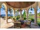 Elegant outdoor patio area with lake views, ornate columns, comfortable seating, and a cozy fire pit at 11900 Lake Butler Blvd, Windermere, FL 34786
