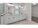 Elegant bathroom featuring double sinks, white cabinets, and a walk-in closet at 13415 Laxness St, Orlando, FL 32827