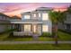 Two-story home with gray siding, stone accents, and a metal roof at 13415 Laxness St, Orlando, FL 32827