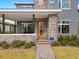 Two-story home with gray siding, stone accents, and a metal roof at 13415 Laxness St, Orlando, FL 32827