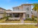 Two-story home with gray siding, stone accents, and a metal roof at 13415 Laxness St, Orlando, FL 32827