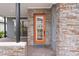 Modern home exterior with orange front door and stone accents at 13415 Laxness St, Orlando, FL 32827