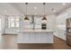 Modern kitchen with large island, stainless steel appliances, and pendant lighting at 13415 Laxness St, Orlando, FL 32827