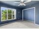 Bedroom with blue walls and a large window at 1423 Grand Cayman Cir, Winter Haven, FL 33884