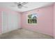 Bedroom with pink walls, carpet, and built-in closet at 1423 Grand Cayman Cir, Winter Haven, FL 33884
