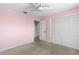 Bedroom with pink walls, carpet, and built-in closet at 1423 Grand Cayman Cir, Winter Haven, FL 33884