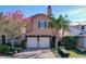 Tan two-story house with two-car garage and lush landscaping at 16324 Vetta Dr, Montverde, FL 34756
