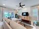 Living area with sectional sofa, TV, and access to a backyard patio at 16324 Vetta Dr, Montverde, FL 34756