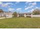 Single-story home with a green front lawn and an attached garage, next to mature trees at 191 Royal Dunes Cir, Ormond Beach, FL 32176