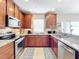 L-shaped kitchen with wood cabinets and granite countertops at 2093 Leather Fern Dr, Ocoee, FL 34761