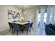 Modern dining room with square wooden table and blue chairs, near sliding doors at 230 Jetty Way, Davenport, FL 33897