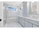 Bright bathroom featuring double sinks, plentiful cabinet space, soaking tub, and frameless glass shower at 2315 Depauw Ave, Orlando, FL 32804