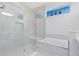 Bright bathroom featuring frameless glass shower and soaking tub with marble surround at 2315 Depauw Ave, Orlando, FL 32804