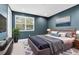 Stylish bedroom featuring a blue accent wall, a large window, a king bed, and soft rug at 2315 Depauw Ave, Orlando, FL 32804