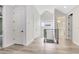 Bright hallway with modern railing, doors, and light wood-look flooring leading to a bathroom at 2315 Depauw Ave, Orlando, FL 32804