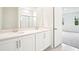 Modern bathroom with dual sinks, quartz counters, white cabinets and shower with glass door at 2437 Zuni Rd, St Cloud, FL 34771