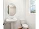 Well-lit half bathroom showcasing a pedestal sink, a toilet, and a window with a view at 2437 Zuni Rd, St Cloud, FL 34771