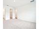 A bedroom with carpet and two doorways, one leading to a bathroom and walk-in closet at 2437 Zuni Rd, St Cloud, FL 34771