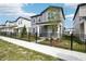 Charming two-story home with gray siding and a well-manicured front yard enclosed by a classic black metal fence at 2437 Zuni Rd, St Cloud, FL 34771