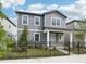 Charming two-story home with gray siding and a well-manicured front yard enclosed by a classic black metal fence at 2437 Zuni Rd, St Cloud, FL 34771