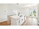 Open-concept kitchen with island, stainless steel appliances, and bright white cabinets, flows into the dining area at 2437 Zuni Rd, St Cloud, FL 34771
