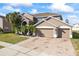 Two-story house with a three-car garage and landscaped yard at 2606 Maggiore Cir, Kissimmee, FL 34746