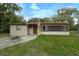 Ranch-style home with a spacious lawn and American flag at 2704 Magnolia Ave, Sanford, FL 32773