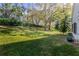 Landscaped backyard with lush green grass and mature trees at 3667 Kingswood Ct, Clermont, FL 34711