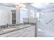 Modern bathroom with double vanity, granite countertop, and walk-in shower at 3667 Kingswood Ct, Clermont, FL 34711
