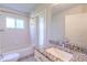 Bathroom with granite countertop, white cabinets, and a bathtub at 3667 Kingswood Ct, Clermont, FL 34711