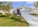 House exterior with gray paint, landscaping and driveway at 3667 Kingswood Ct, Clermont, FL 34711
