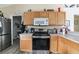 Bright kitchen with wood cabinets, stainless steel appliances, and laminate flooring at 459 Abeno Ave, Deltona, FL 32725