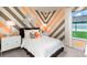Bedroom with chevron-patterned walls, white bedding, and a window at 5296 Bowspirit Way, St Cloud, FL 34769