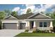Two-story house with gray and beige siding, two-car garage, and landscaping at 5296 Bowspirit Way, St Cloud, FL 34769