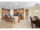 Open kitchen with ample wood cabinetry, granite counters, and island with seating at 590 Michigan Estates Cir, St Cloud, FL 34769