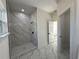 Large shower with marble tile and modern fixtures at 702 Marion Oaks Manor, Ocala, FL 34473