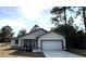 Newly constructed home with white exterior, black accents, and a two-car garage at 702 Marion Oaks Manor, Ocala, FL 34473