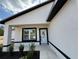 New home with white exterior, black accents, and a covered entryway at 702 Marion Oaks Manor, Ocala, FL 34473