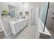 Bright bathroom featuring double sink vanity, tiled floor, and glass-enclosed walk-in shower at 7149 Dilly Lake Ave, Groveland, FL 34736