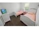 Cozy bedroom featuring matching twin beds, dark floors, and bright natural light from the window at 7149 Dilly Lake Ave, Groveland, FL 34736