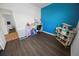 A versatile bedroom features a blue accent wall, laminate floors, desk and a play area at 7149 Dilly Lake Ave, Groveland, FL 34736