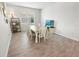 Dining area featuring wood-look tile flooring, a table with six chairs, natural lighting, and a television at 7149 Dilly Lake Ave, Groveland, FL 34736