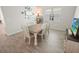 Dining area featuring wood-look tile flooring, a table with six chairs, natural lighting, and a television at 7149 Dilly Lake Ave, Groveland, FL 34736