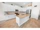 Bright kitchen boasts white cabinetry, stainless steel appliances, and a large center island perfect for meal prep at 7149 Dilly Lake Ave, Groveland, FL 34736
