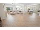 Open-concept living and dining area with wood-look tile flooring, large sectional sofa, and dining table with seating at 7149 Dilly Lake Ave, Groveland, FL 34736