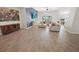 Open-concept living room featuring wood-look tile flooring and a stylish accent wall with large sectional sofa at 7149 Dilly Lake Ave, Groveland, FL 34736