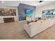 Open-concept living room featuring wood-look tile flooring and a stylish accent wall with large sectional sofa at 7149 Dilly Lake Ave, Groveland, FL 34736