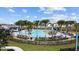 Resort-style pool featuring palm trees, comfortable lounge chairs, and splash pad under clear blue skies at 7149 Dilly Lake Ave, Groveland, FL 34736